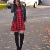 Red dress sa isang hawla na may kumbinasyon ng mga bota at leather jacket