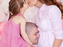 Photo session of a pregnant woman with her husband and child in a photo studio