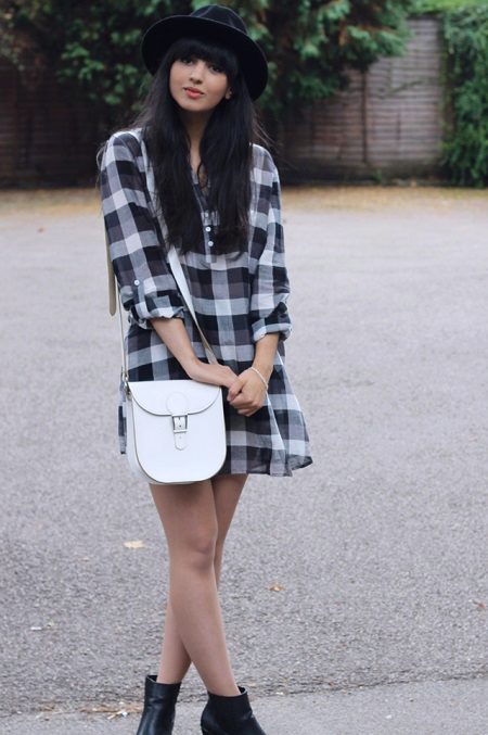 Mặc áo sơ mi trong lồng kết hợp với túi xách màu trắng trên dây đeo dài, giày đen và mũ